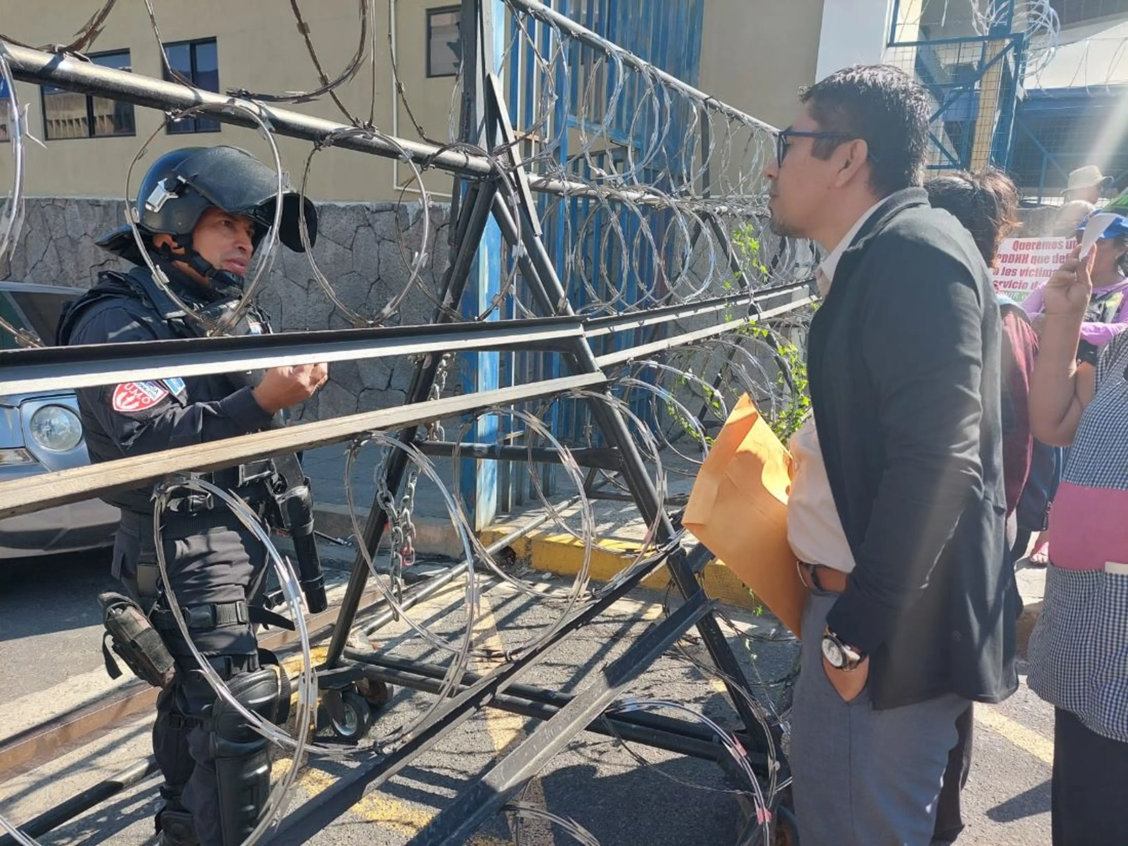 Member of Tutela Legal talking to a Salvadoran national police officer